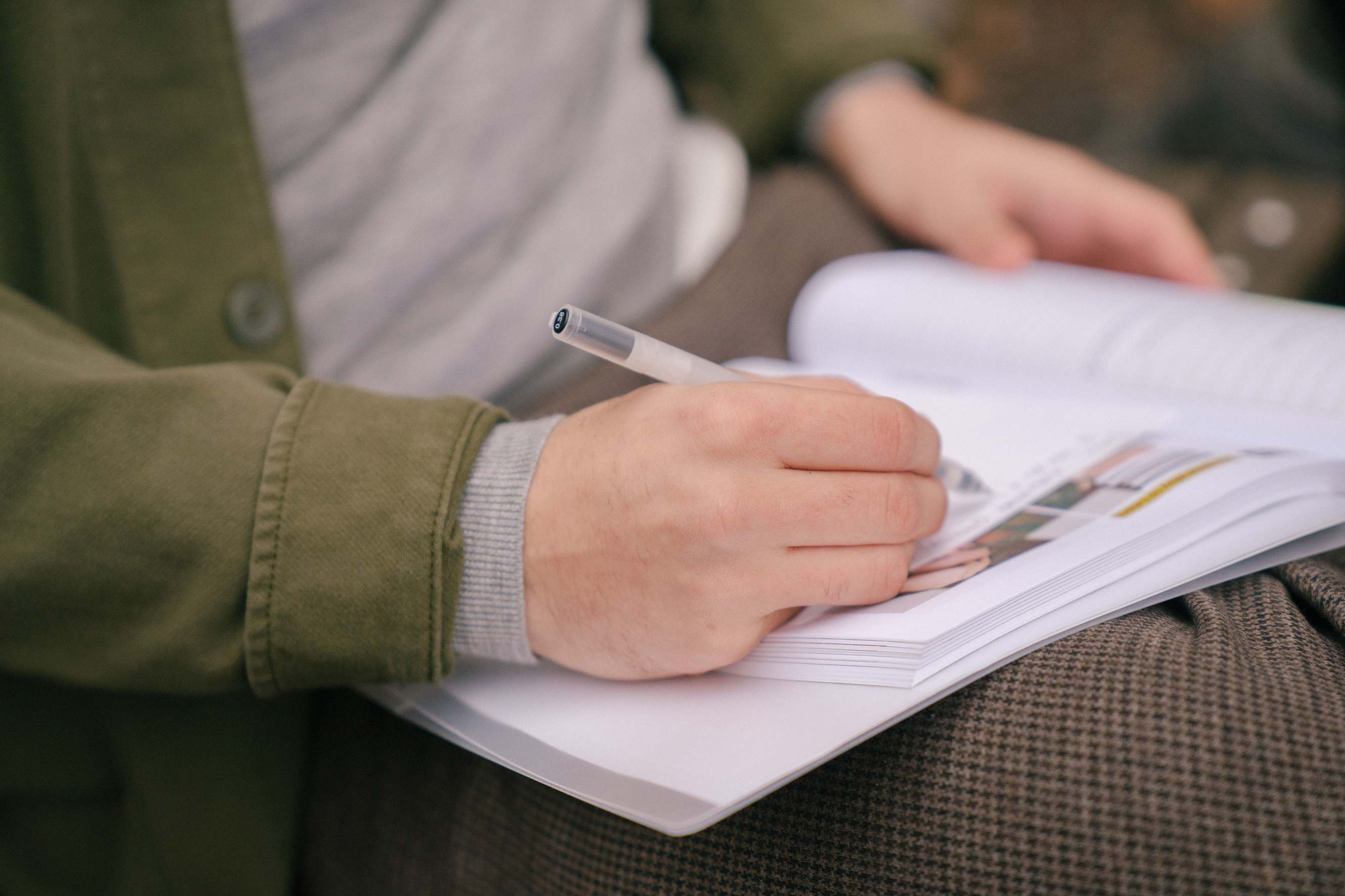 Arbeitsplatz mit Tabellenkalkulation und Unterlagen, Workbook und handschriftliche Einträge