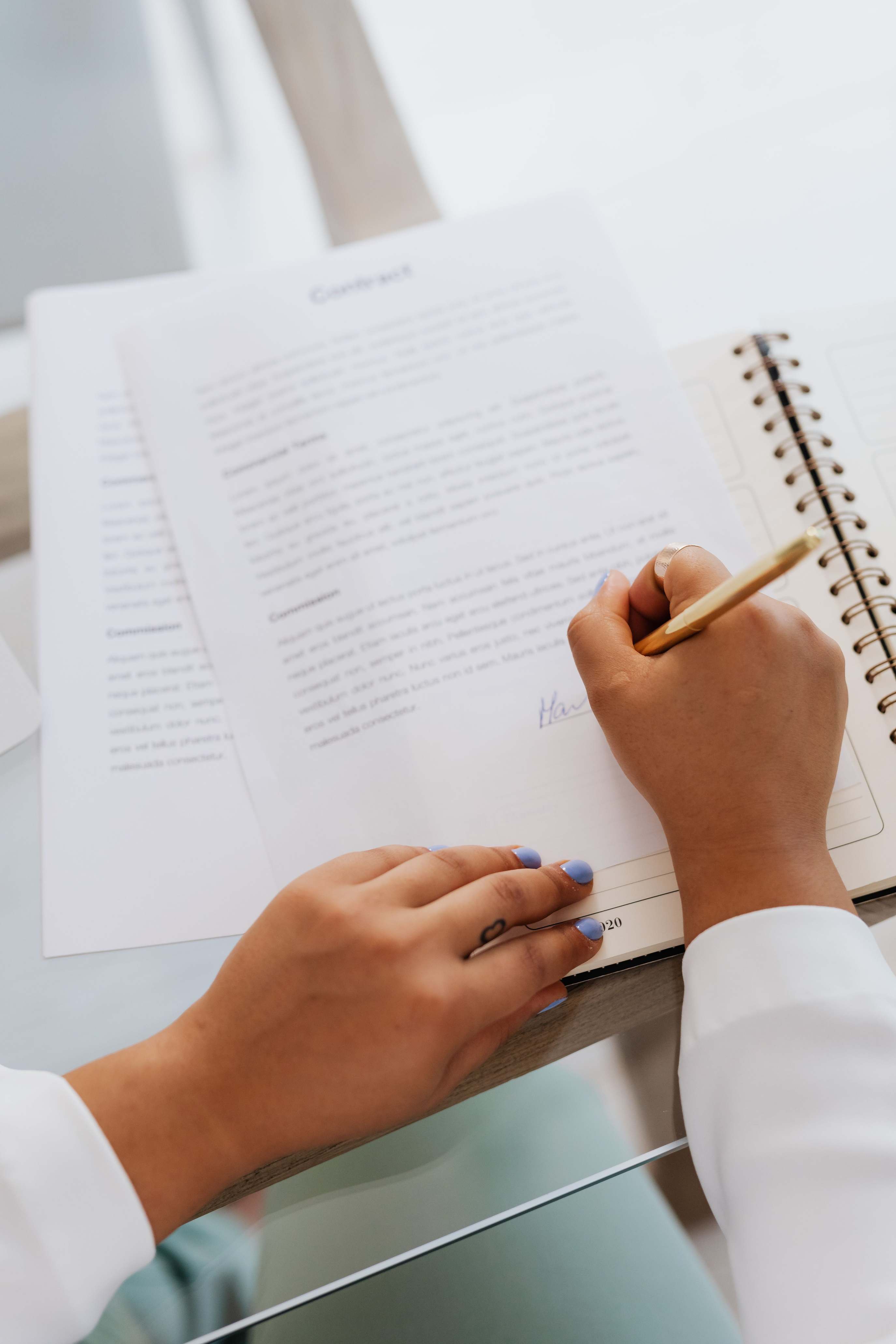 Handschriftliche Notizen neben einem Kontoblatt, Hände beim Unterschreiben eines Vertrags